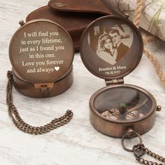 two personalized pocket watches on a table with a chain around it and a wallet in the background