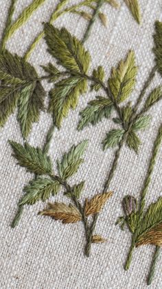 close up of embroidery on fabric with green leaves