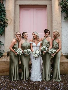 a group of women standing next to each other in front of a door with flowers