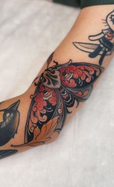 a woman's arm with tattoos on it and a bird sitting on top of the arm