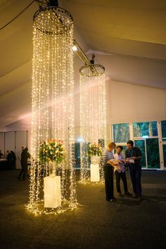 two people are standing under some lights