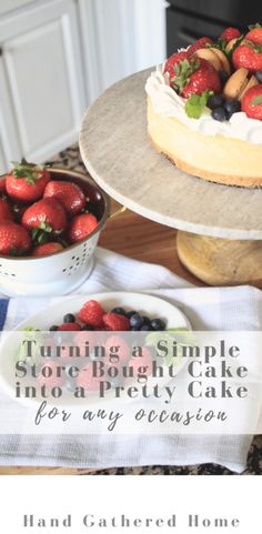 a cake with strawberries and blueberries on it sitting on top of a table