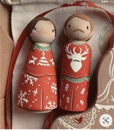 two wooden figurines sitting next to each other on top of a cloth bag