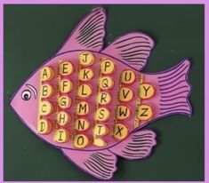 a pink fish shaped magnet with letters on it