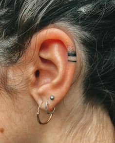 an ear piercing is seen in this close up photo, with the top part of the ear visible