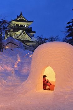 a person sitting in an igloose at night