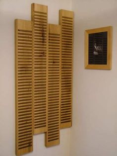 there is a window with wooden shutters on the wall next to a small window