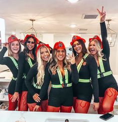 the women are dressed in red and black outfits, posing for a photo with each other