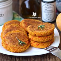 some carrot cakes on a white plate with a fork and jar of honey in the background