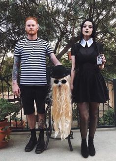 a man and woman dressed in costumes standing next to each other near a bicycle with long blonde hair