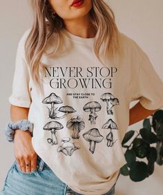 "Trendy Shirt with print in front, this shirt has all a positive message in the front, encouraging words. Perfect to give as gift. A cute mushroom shirt . Trendy Goblincore Clothes Q U I C K * F A C T S * ♥️50% Cotton; 50% Polyester ♥️ Loose fit ♥️ Wash and dry normally. Do not iron directly on the print. * S I Z I N G * ♥️ Loose fit ♥️Most women find their typical size works best. ♥️ Please see size guide in last listing photo for all measurements and information Chest / Lengh S - 20\"-26\" M - Relaxed Fit Graphic Tee With Mushroom Print, Vintage Cotton T-shirt With Mushroom Print, Relaxed Fit Tops With Mushroom Print For Streetwear, Vintage Relaxed Fit Tops With Mushroom Print, Relaxed Fit Mushroom Print Top For Streetwear, Crew Neck Cotton Shirt With Mushroom Print, Cotton Crew Neck Shirt With Mushroom Print, Cotton Shirt With Mushroom Print, Mushroom Print Cotton Top For Streetwear