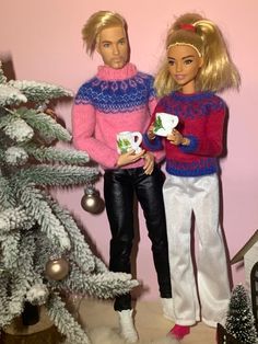 two barbie dolls standing next to each other in front of a christmas tree with ornaments