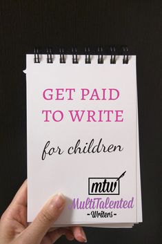 a hand holding up a notebook with writing on it and the words get paid to write for children