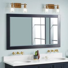 a bathroom with two sinks and a large mirror above the double sink vanity area is shown