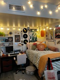 a bed room with a neatly made bed and lots of lights hanging from the ceiling