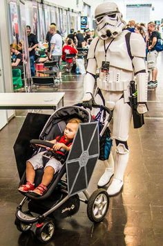 a baby in a stroller is being pushed by a storm trooper