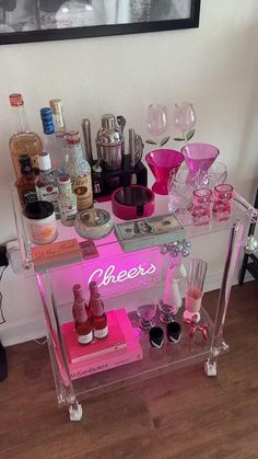 a pink bar cart filled with bottles and glasses