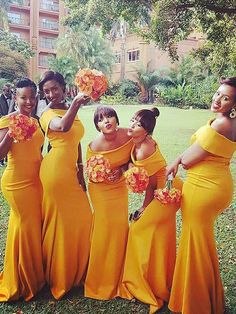 a group of women in yellow dresses standing next to each other on a grass covered field