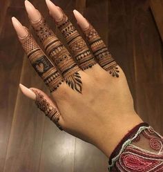 a woman's hand with henna tattoos on it