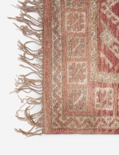 an old rug with fringes on the bottom and one piece of fabric hanging from it