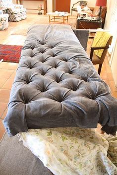 a couch that is sitting in the middle of a living room with a blanket on top of it