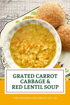 a bowl of carrot cabbage and red lentil soup with two rolls on the side