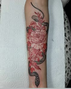 a snake and roses tattoo on the arm