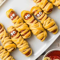 hot dogs wrapped in pretzels with googly eyes on them, ready to be eaten