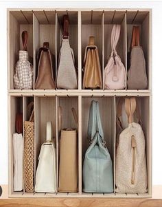 several purses are lined up in a wooden box