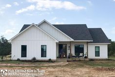 a white house sitting on top of a dirt field