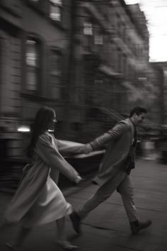 black and white photograph of two people walking down the street with their arms around each other