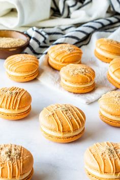 pumpkin cheesecake macarons on a baking sheet with the title in the middle