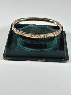 Great vintage hinged bangle bracelet. Signed 12 K GF BOJAR.  Inscribed inside with the date 10-25-80.   7  inches around.  1/4 inch wide.  Good vintage condition - some surface scratches and there is a small dent on the back - see the last photo.  Button easily works to open and close. Hinged Bangle, Bangle Bracelet, Etching, Hinges, Gold Filled, Bangle Bracelets, 4 Inch, Jewelry Bracelets, Bangles