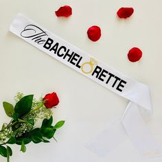 a bouquet of roses and a white ribbon with the words baache rette on it