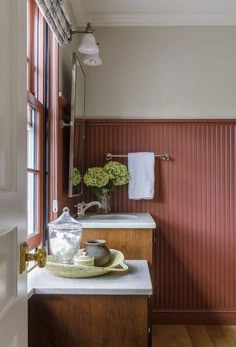 a bathroom with a sink, mirror and towel rack on the counter next to it