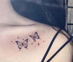 the back of a woman's shoulder with two butterflies on it and stars in the sky