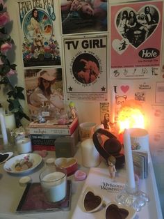 a table topped with lots of food and drinks next to a wall covered in posters