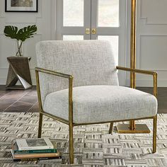 a white chair sitting on top of a rug next to a window