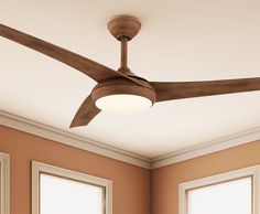 a ceiling fan in a room with two windows