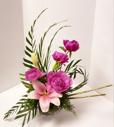 a vase filled with pink flowers and greenery