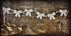 a string of paper bows on a wooden surface