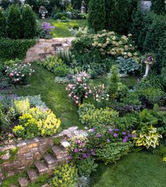 a garden with lots of flowers and plants growing on the side of it's sides