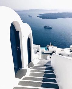 the stairs lead up to an open door with a boat in the water behind them