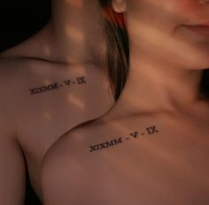 a woman's chest with roman numerals tattooed on her left arm and shoulder