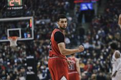 a basketball player in red and black uniform on the court