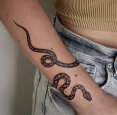 a woman's arm with a tattoo on it that is shaped like a snake