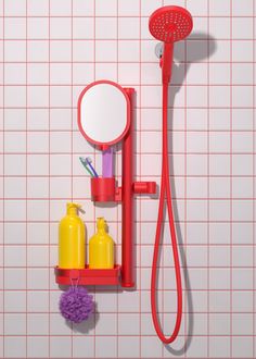 there is a red shower head and soap dispenser on the wall