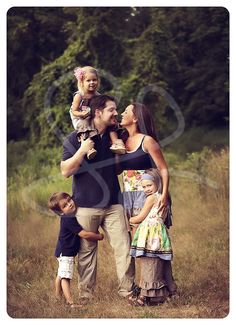 a family is posing for a photo in the grass