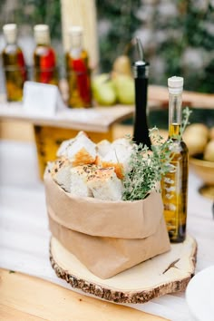 an assortment of food and wine on a table with other foods in the back ground