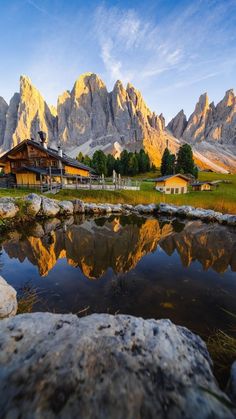 there is a mountain range in the background with water and rocks on the foreground